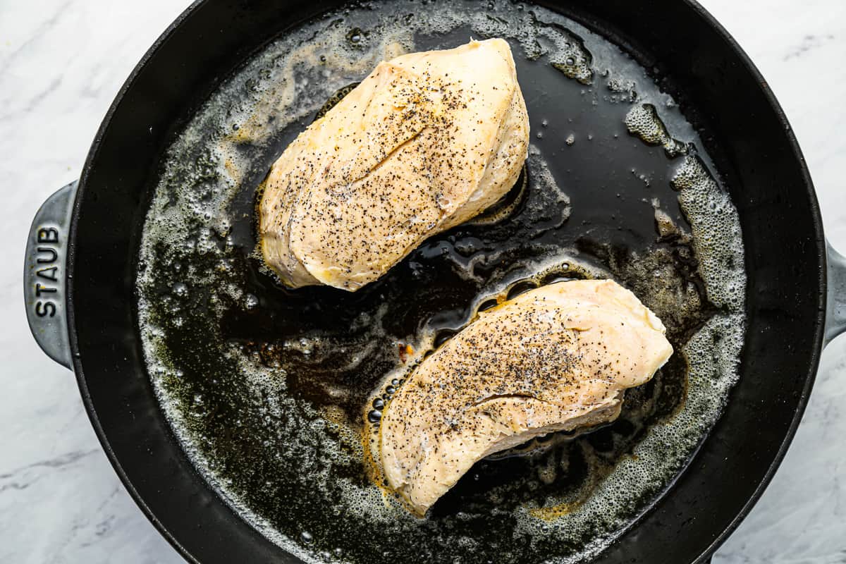 2 peitos de frango sous vide cozidos e tostados em uma panela de ferro fundido.