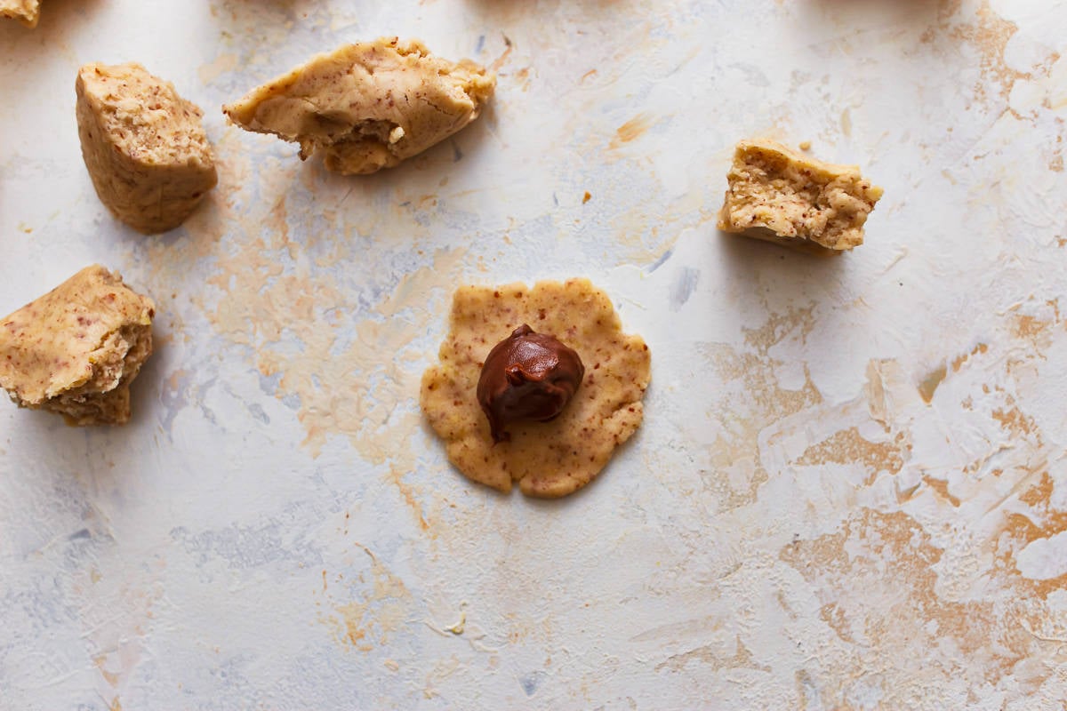 Bola de nutella colocada no centro de um pedaço de massa de biscoito.