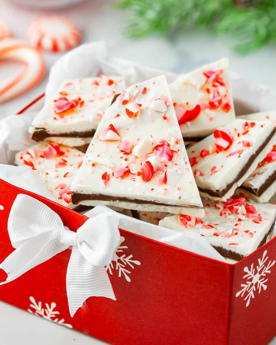 Casca de hortelã-pimenta de chocolate em uma caixa de presente de Natal vermelha com bastões de doces.