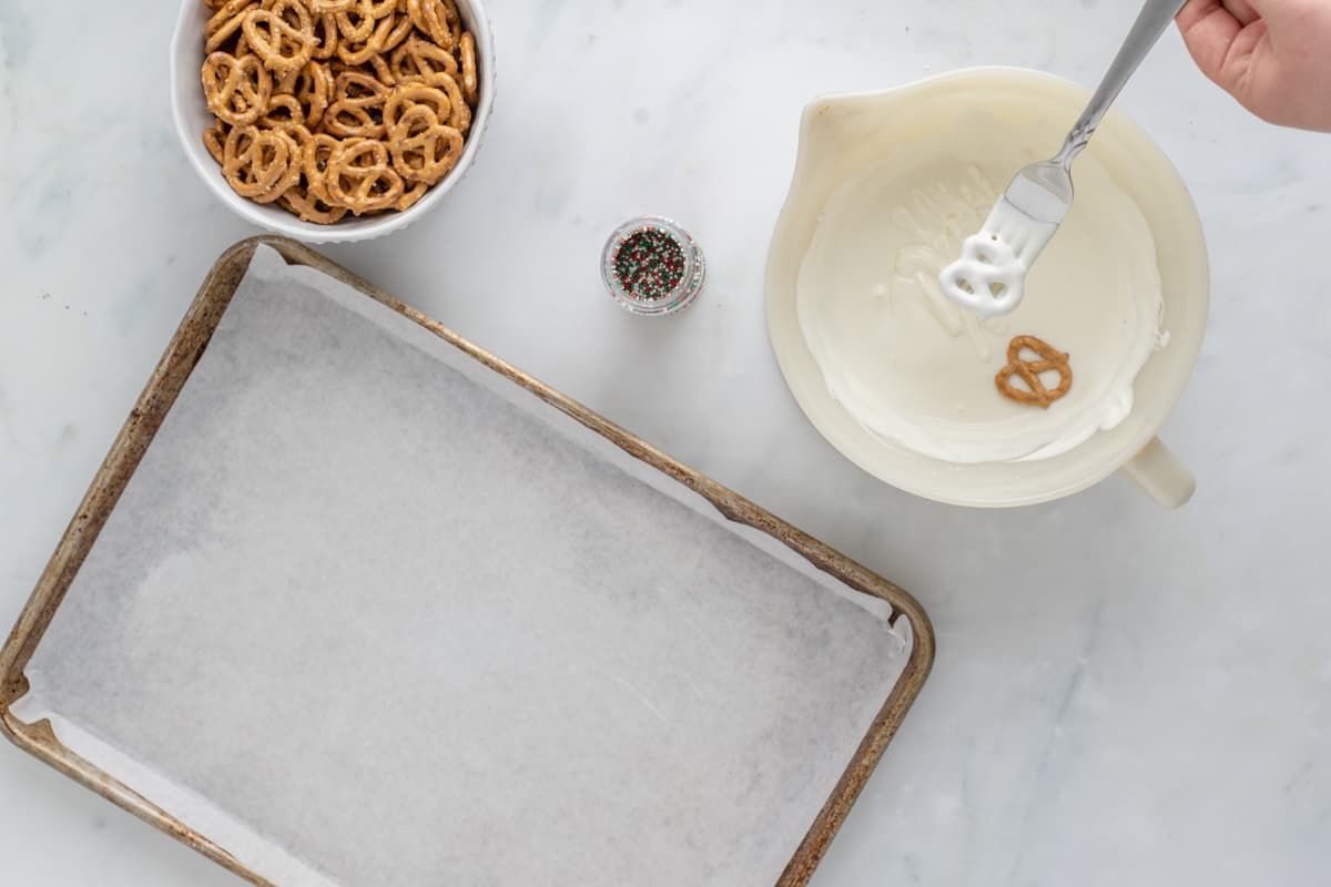 uma pessoa está misturando pretzels em uma tigela com uma colher.