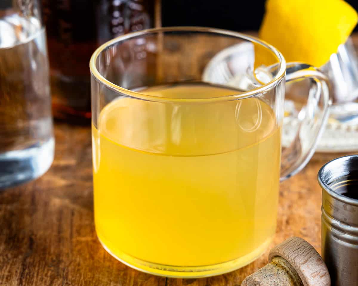 Uma caneca de limonada com uma rodela de limão ao lado.