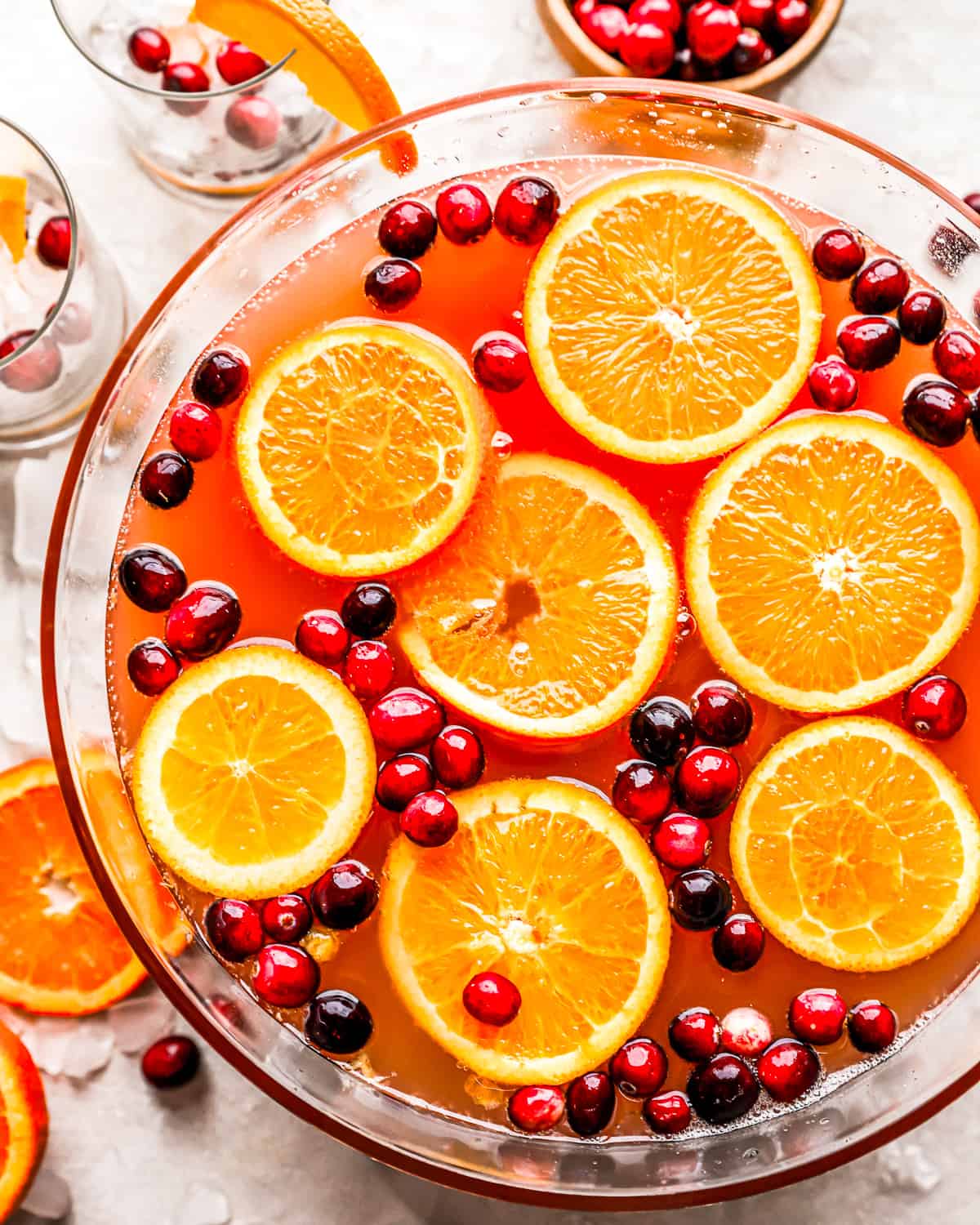 Uma tigela cheia de laranjas e cranberries.