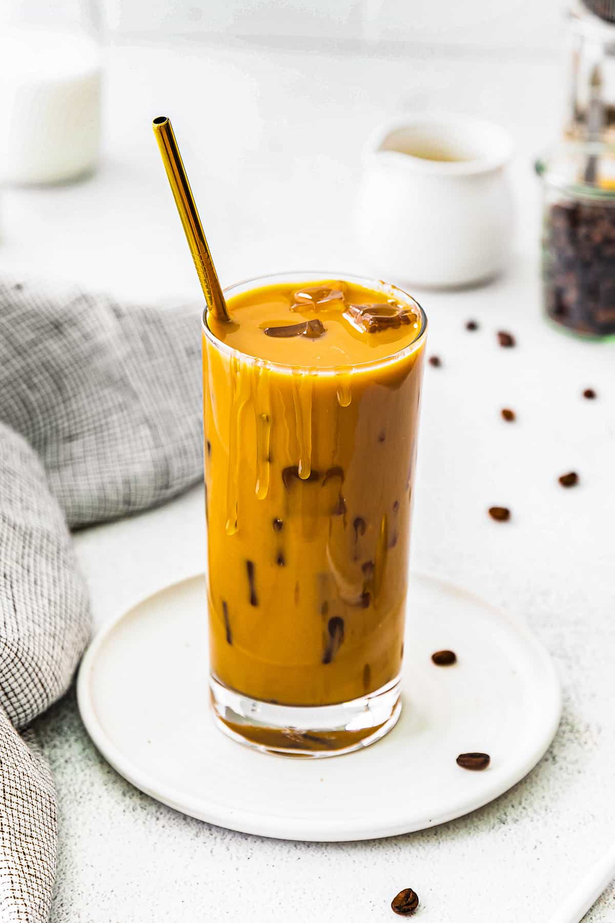 café com leite de caramelo gelado mexido em copo com canudo dourado