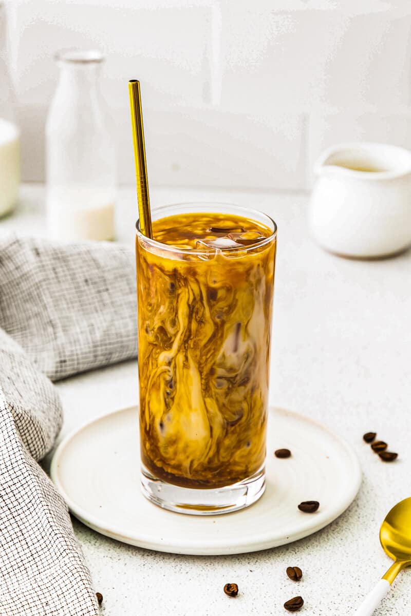 café com leite de caramelo gelado em copo alto transparente com canudo