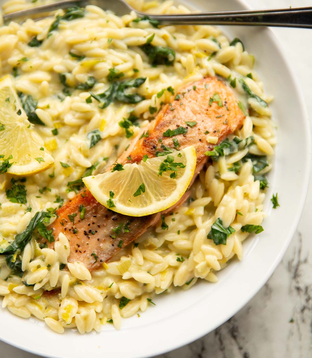 boursin salmon orzo served in large white bowl with lemon and fresh parsley