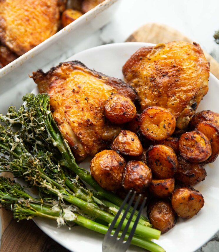close-up de frango assado e batatas em um pequeno prato branco com brócolis