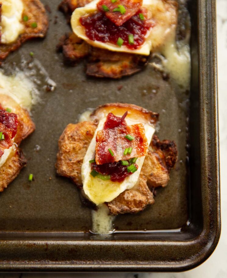 close-up de batata brie com bacon e cranberry recém-saída do forno na assadeira
