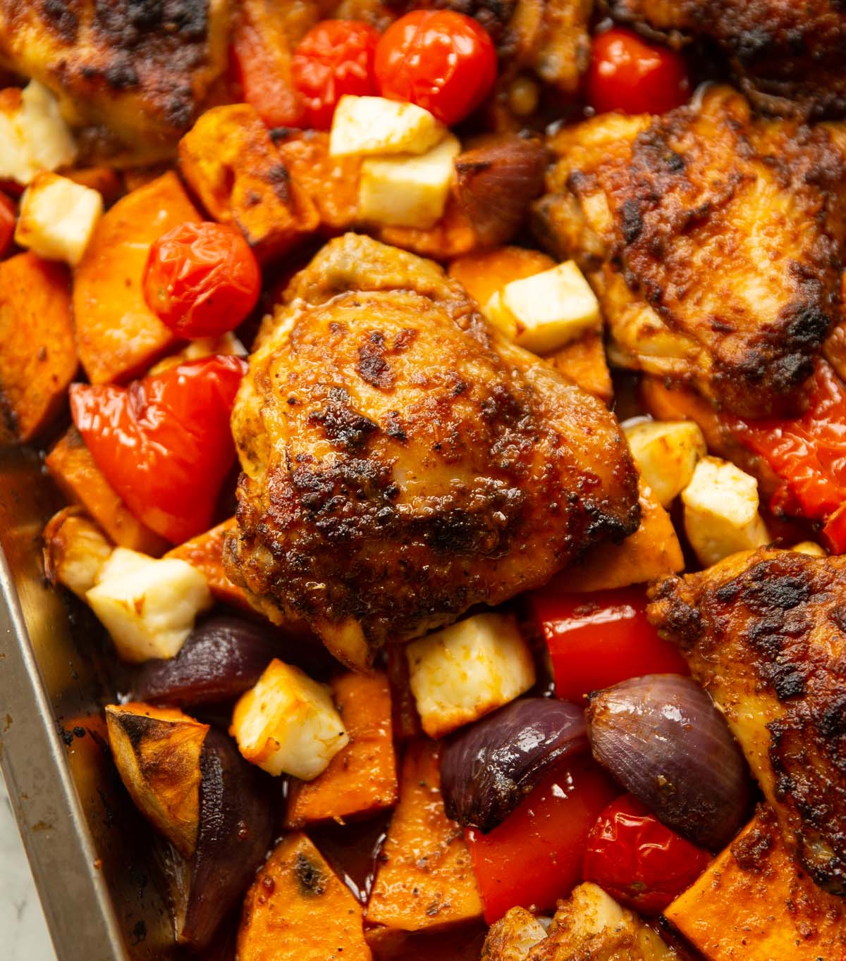close up shot of peri peri chicken traybake fresh out the oven