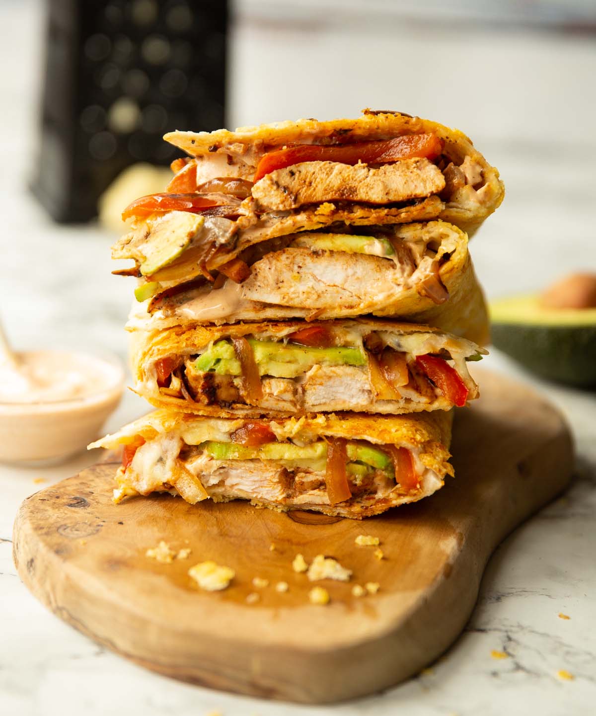 4 chipotle chicken quesadillas quarters stacked on each other on wooden board