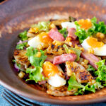 Salada de presunto com abacaxi grelhado, ovos cozidos e batatas com sobreposição de título.
