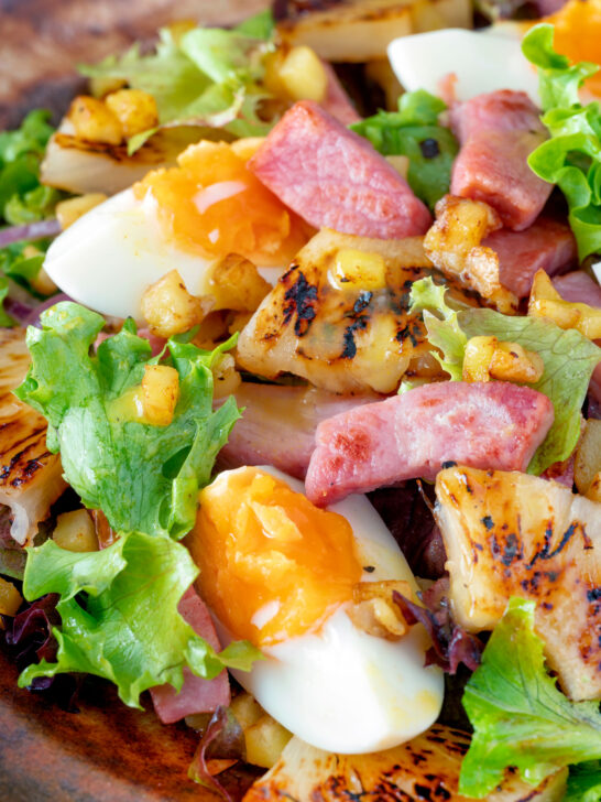 Feche a salada de pernil com abacaxi grelhado, ovos cozidos e batatas.