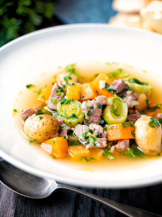 Welsh cawl, uma sopa à base de caldo de cordeiro e vegetais em uma tigela branca.