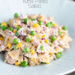 Salada de macarrão de atum com ervilha, milho e cebola roxa com sobreposição de título.